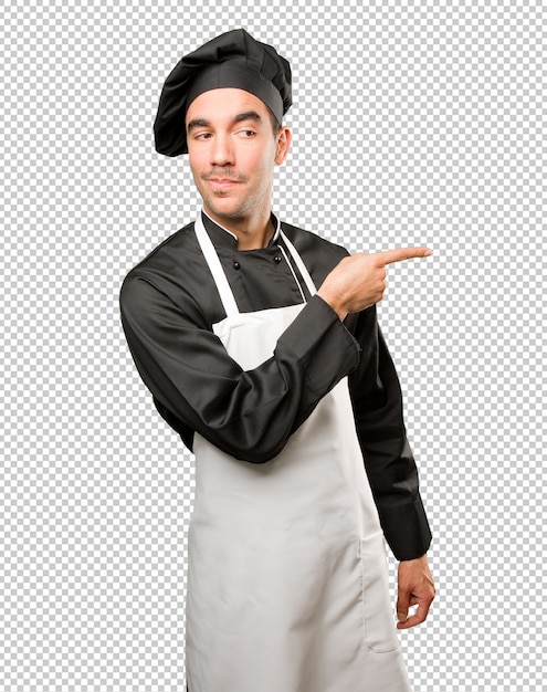 Jovem cozinheiro pensativo apontando