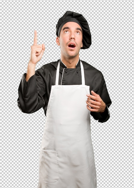 Jovem cozinheiro pensativo apontando