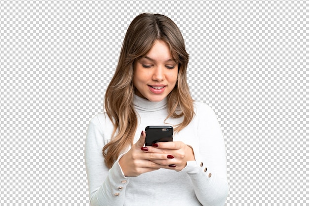 Jovem garota sobre fundo de chave de croma isolado enviando uma mensagem ou e-mail com o celular
