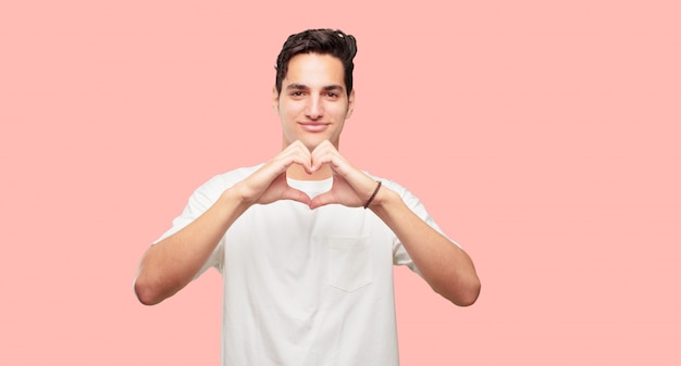 Jovem homem bonito sorrindo, olhando feliz e apaixonado