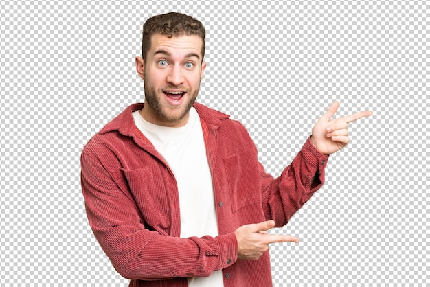 Jovem homem loiro bonito sobre isolado chroma chave fundo surpreso e apontando lado