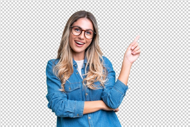 Jovem mulher uruguaia sobre fundo isolado feliz e apontando para cima