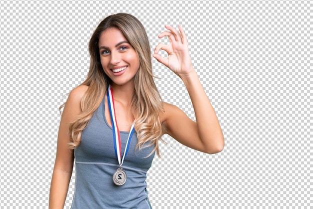PSD jovem mulher uruguaiana bonita e desportiva com medalhas sobre um fundo isolado mostrando o sinal ok com os dedos