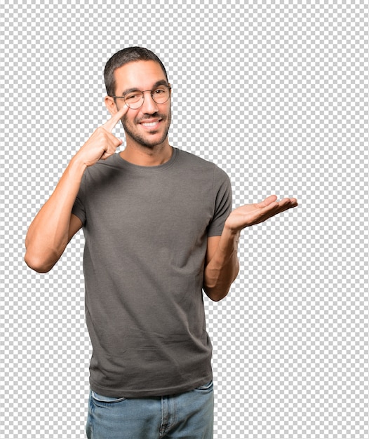 Jovem simpático fazendo um gesto de cuidado com a mão apontando para o olho