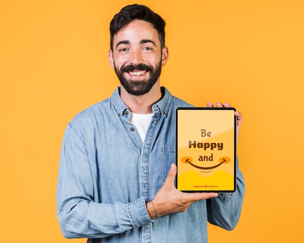 Jovem sorridente segurando o tablet simulado