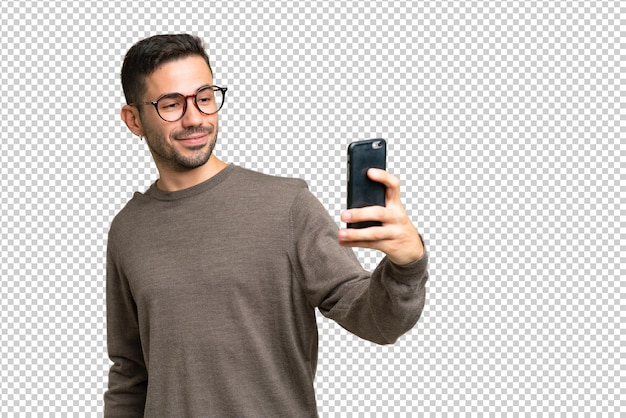 Joven apuesto hombre caucásico sobre un fondo aislado haciendo un selfie