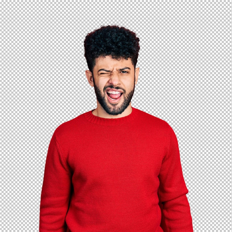 PSD joven árabe con barba que lleva un suéter rojo casual guiñando el ojo mirando a la cámara con una expresión sexy rostro alegre y feliz