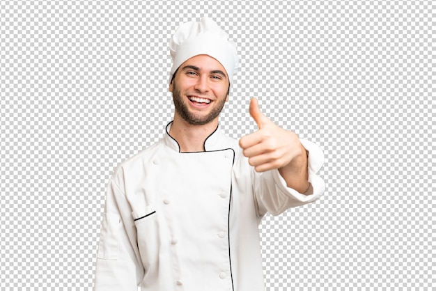 Joven chef apuesto sobre un fondo aislado con los pulgares hacia arriba porque algo bueno ha sucedido