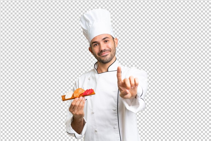 PSD joven chef caucásico sosteniendo un sushi sobre un fondo aislado mostrando y levantando un dedo