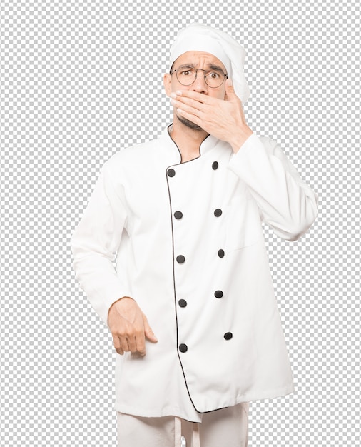 Joven chef cubriéndose la boca con las manos