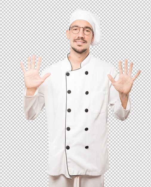 Joven chef haciendo un gesto número diez