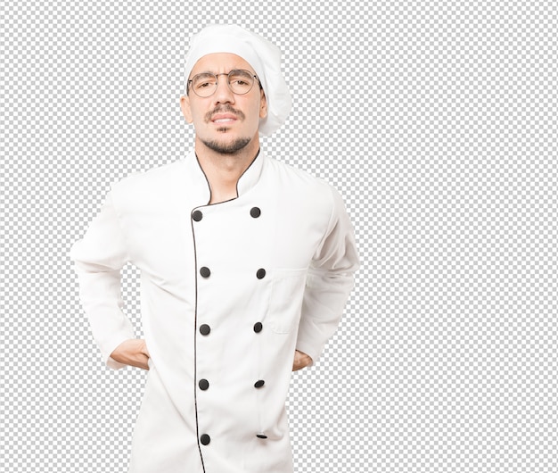 Joven chef preocupado con un gesto de dolor