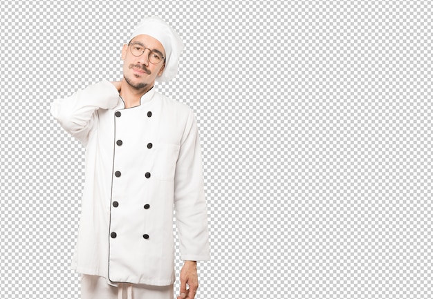 Joven chef preocupado con un gesto de dolor