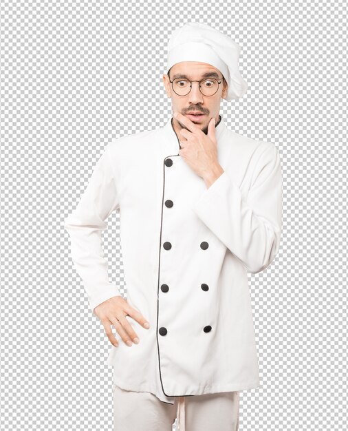 Joven chef preocupado posando sobre fondo