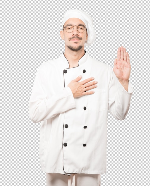 Joven chef serio con un gesto de juramento