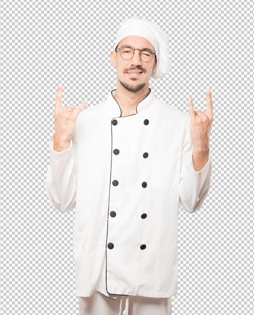 Joven chef travieso haciendo un gesto de rock