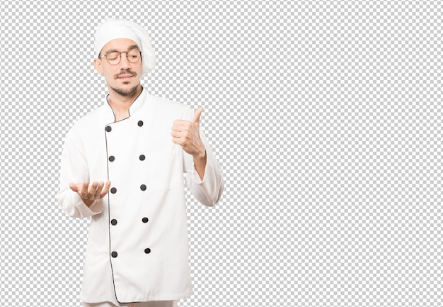 Joven chef vacilante gesticulando que todo está bien