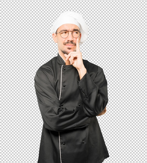 Joven chef vacilante mirando gesto