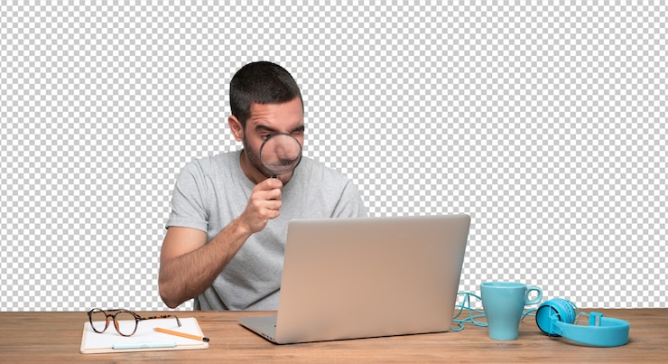 PSD joven concentrado usando una lupa en su computadora portátil