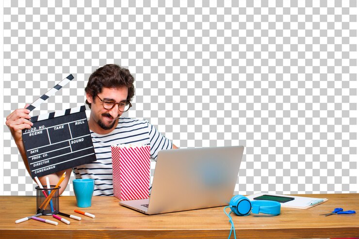 PSD joven diseñador gráfico loco en un escritorio con una computadora portátil y con una claqueta de cine