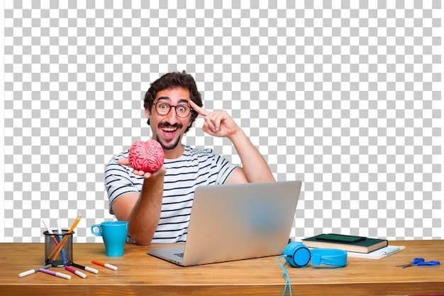 Joven diseñador gráfico loco en un escritorio con una computadora portátil y con un modelo de cerebro