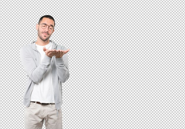 Joven dudoso sosteniendo algo con la mano