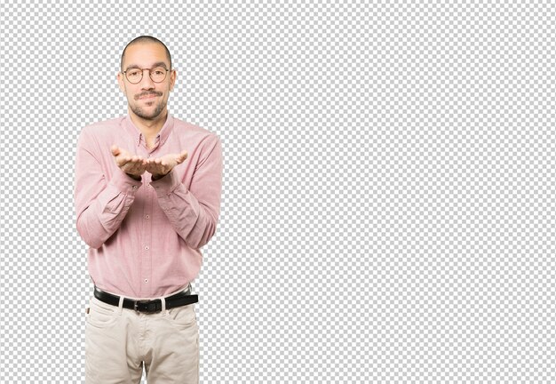 Joven dudoso sosteniendo algo con la mano