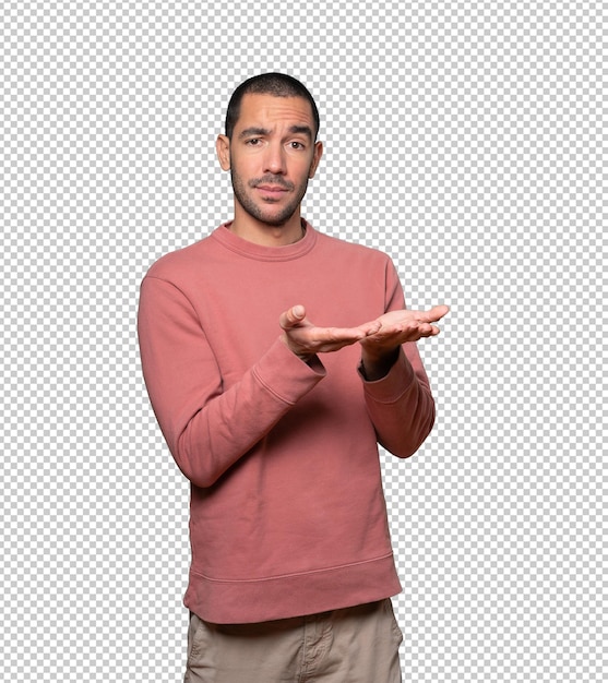 Joven dudoso sosteniendo algo con la mano