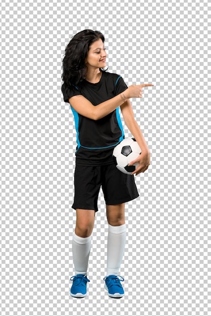 Joven futbolista mujer apuntando hacia un lado para presentar un producto