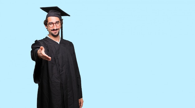 Joven graduado con una expresión sonriente, segura, orgullosa, satisfecha y amigable