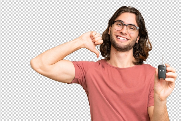 Joven hombre guapo sosteniendo las llaves del coche sobre un fondo aislado orgulloso y satisfecho de sí mismo