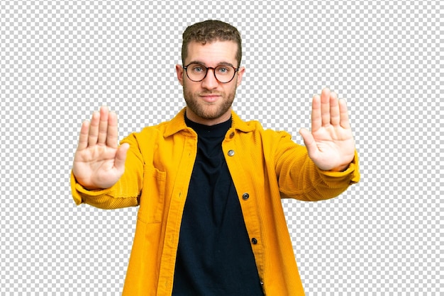 Joven hombre rubio guapo sobre aislado chroma clave de fondo haciendo stop gesto y decepcionado
