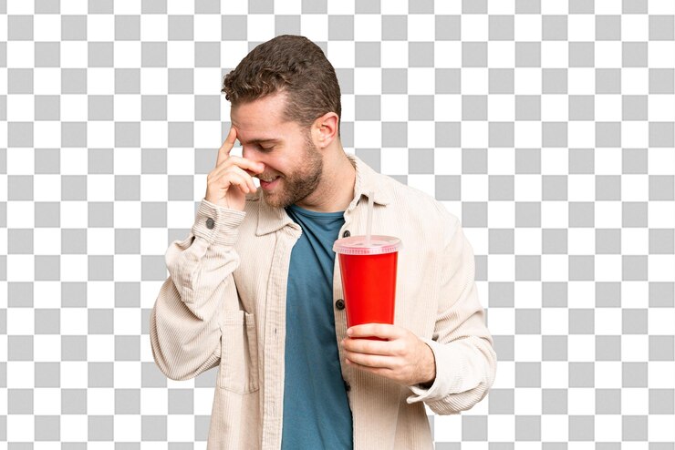 PSD joven hombre rubio guapo sosteniendo refresco sobre aislado chroma clave de fondo riendo
