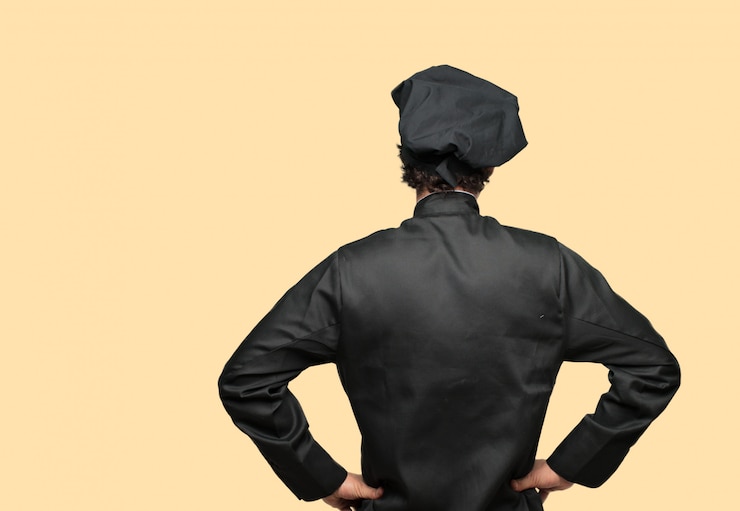 PSD joven loco como chef con un aspecto orgulloso, satisfecho y feliz, con ambas manos en las caderas