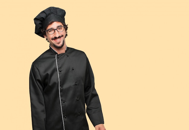 joven loco como chef con una mirada satisfecha y feliz en su rostro