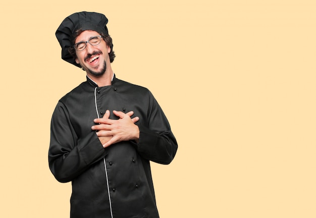 joven loco como un chef riendo en voz alta con la cabeza inclinada hacia atrás y alegre, alegre expresión