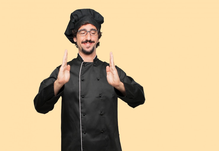 PSD joven loco como un chef sonriendo con una expresión satisfecha que muestra un objeto o concepto