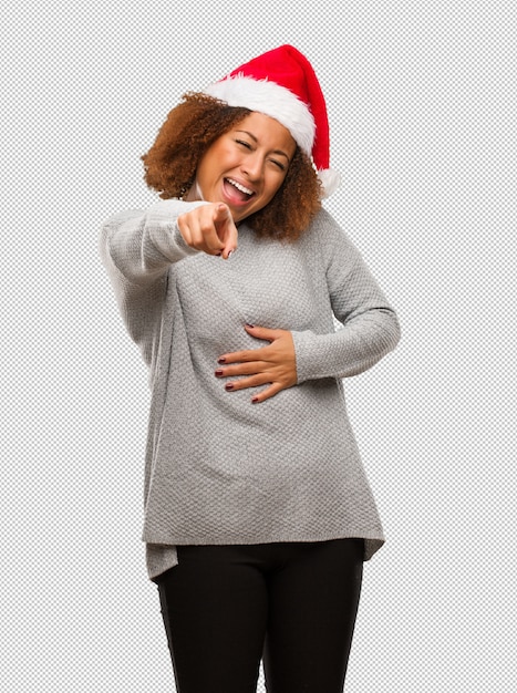 Joven mujer negra con un sombrero de santa sueña con alcanzar metas y propósitos