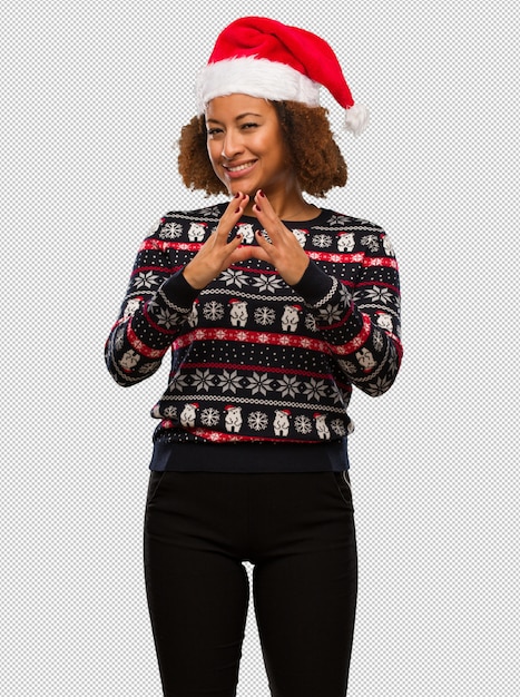Joven mujer negra en un suéter navideño de moda con estampado ideando un plan
