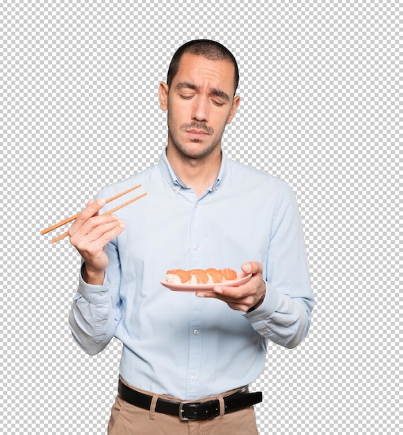 Joven con palillos para comer sushi