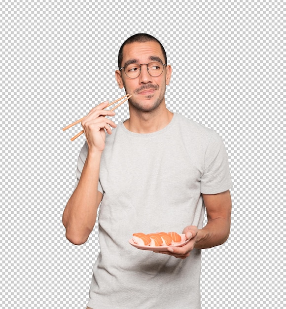 Joven con palillos para comer sushi