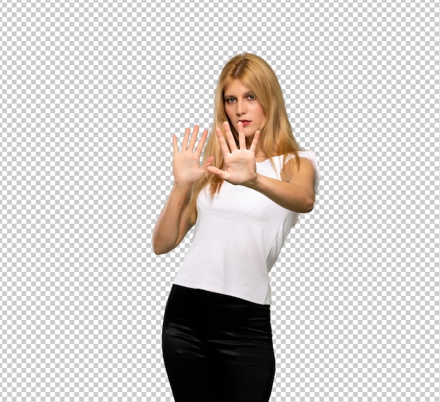 La joven rubia está un poco nerviosa y asustada estirando las manos hacia el frente.