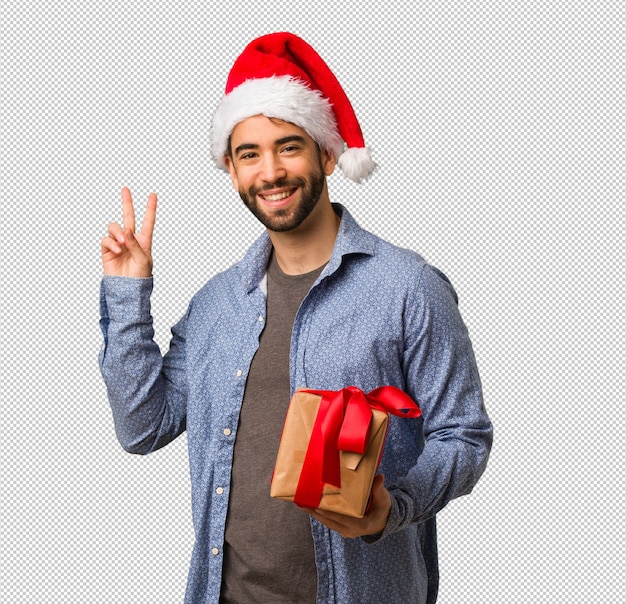 Joven con sombrero de santa haciendo un gesto de victoria