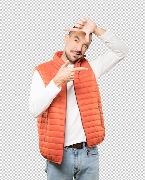 Joven sorprendido haciendo un gesto de tomar una foto con las manos