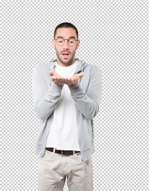 Joven sorprendido sosteniendo algo con la mano