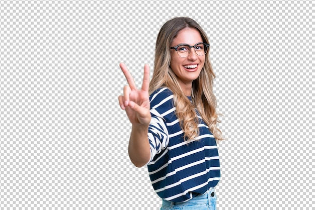 Una joven uruguaya sobre un fondo aislado sonriendo y mostrando la señal de la victoria