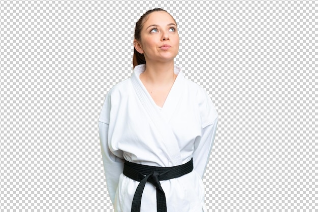 Junge blonde Frau macht Karate über isolierter Chromakey-Hintergrund und schaut nach oben