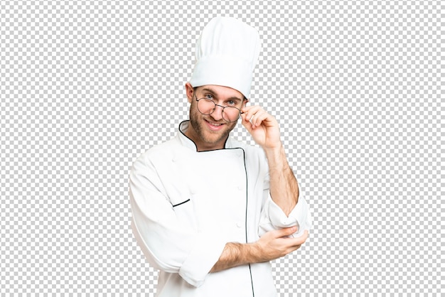 Junge blonde Mann Koch über isolierter Chromakey-Hintergrund mit Brille und glücklich
