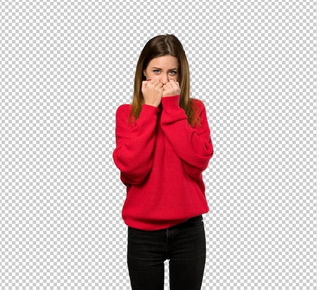 Junge Frau mit roter Strickjacke nervös und erschrocken, die Hände zum Mund setzend