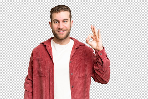 Junge, hübsche, blonde Mann über isolierter Chroma-Schlüssel-Hintergrund, der das OK-Zeichen mit den Fingern zeigt